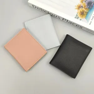 Detailansicht von drei minimalistischen PU-Leder-Kartenetuis in Rosa, Grau und Schwarz.