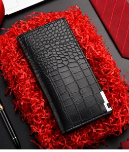 Detalle de cartera larga para hombre en piel negra con textura de cocodrilo y ranuras.