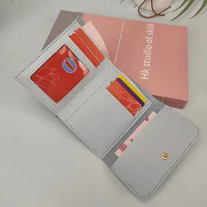 Detailansicht einer hellgrauen Damenbrieftasche mit Kartenfächern und einem Ausweisfenster.