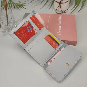Graue kurze dreifach gefaltete Damenbrieftasche mit Kartenfächern und Druckknopf.
