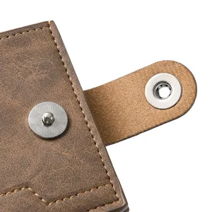 Close-up detail of mens wallet snap button and texture, soft leather material craft.