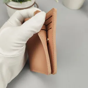 Minimalistisches kurzes Leder-Kartenetui mit mehreren Fächern und feinem Druckknopf.