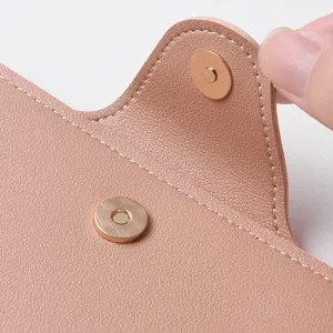 Close-up detail of the women's leather wallet magnetic snap closure and fine stitching texture.