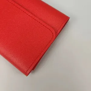 Detailansicht eines roten glatten kurzen Damen Portemonnaies mit feiner Nahtstruktur.