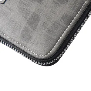 Primo piano dei dettagli del portafoglio in pelle da uomo con cuciture bianche e zip.