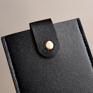 Nahaufnahme des schwarzen PU-Leder-Kartenetuis mit Druckknopfverschluss und strukturierter Oberfläche.