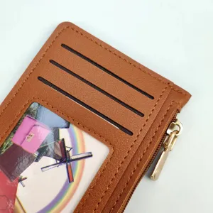 Brown leather card holder detail, slim wallet with card slots and clear ID window.