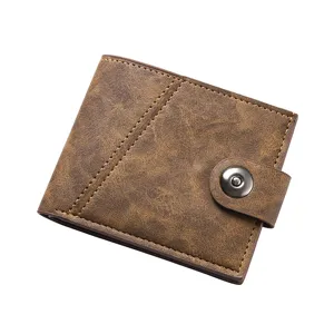 Dettaglio in primo piano del portafoglio corto vintage da uomo marrone con bottone automatico.