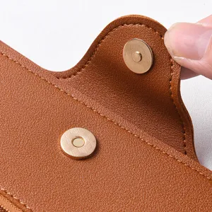 Primo piano dettagliato di portafoglio lungo in pelle marrone con chiusura magnetica.