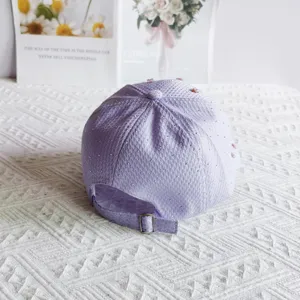 Detailed view of a sweet pastel purple waffle baseball cap with rhinestones and floral decor.