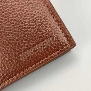 Nahaufnahme Detailansicht braune Herren Ledergeldbörse mit Kontrastnähten und Logo.