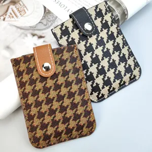 Detail view of stylish houndstooth pull-out card holders with snap button for women storage.