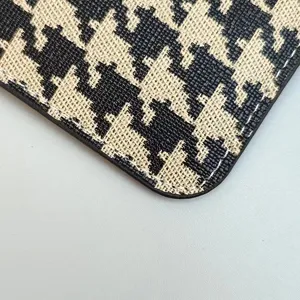 Detailed close-up view of the classic houndstooth card holder texture with neat white stitching.