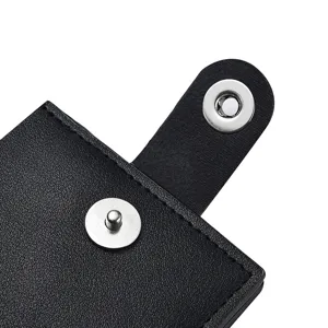 Detail van een korte herenlederen portemonnee met stevige metalen drukknoop en fijne stiksels.