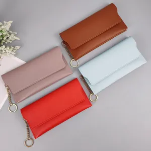 Close-up detail of women solid color long wallet with metal chain and ring clasp design.