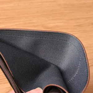 Detailopname van de binnenvoering en de fijne ritssluiting van de herenportemonnee.