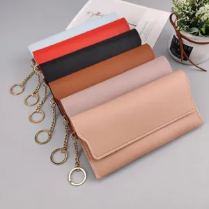 Detailed view of women's long solid color snap button purse with handy keychain attachment.