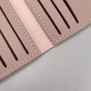 Nahansicht des inneren rosa Lederkartenetuis mit ordentlichen weißen Nähten, viele Fächer.