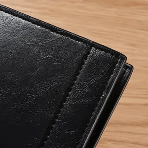 Primo piano dettagliato di un portafoglio in pelle nera con cuciture fini e di pregio.