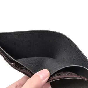 Vue rapprochée de l'intérieur d'un portefeuille court pour homme en cuir souple zippé.