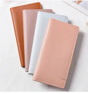 Detail view of multi-color long leather wallets neatly arranged on white background surface.