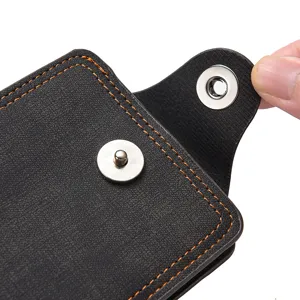 Gros plan portefeuille homme en cuir noir avec bouton-pression, coutures solides, porte-cartes.