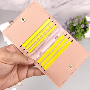 Detailansicht eines schmalen rosa Lederkartenetuis mit mehreren Fächern und Druckknopf.