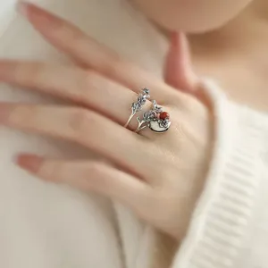 Detailansicht eines Vintage silbernen Rosen-Rankenrings mit kleiner Vogel- und roter Perle.