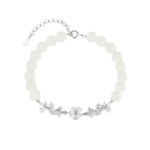 White bead bracelet with sparkling rhinestone flower charms, elegant minimalist jewelry accessory.