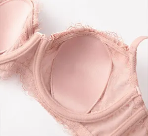 Detailed view of women's pink French lace bra interior lining and delicate floral trim.