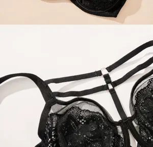 Detail shot of a black lace thin cup bra with multi strappy details and metal rings, elegant design.