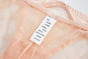 Close up of women lace panties detail showing fabric composition label and soft texture material.