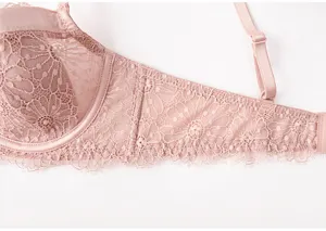 Pink lace French bralette detail shot, showing delicate floral patterns and adjustable straps.