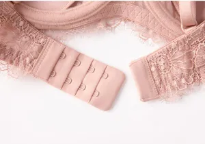 Women's pink lace bra detailed view, featuring delicate floral lace trim and back closure.