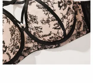 Plus size underwire bra detail shot with mesh embroidery and strappy design.
