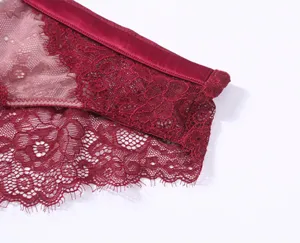 Close-up detail van wijnrode kanten slipje met delicate bloemenpatronen en gladde tailleband.
