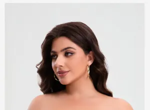 Primo piano dettagliato del reggiseno strapless e degli orecchini a cerchio indossati in studio.
