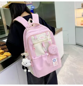 Pink and white student backpack detail showing cute star patches, cloud pendant and pockets.