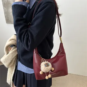 Elegant burgundy dumpling crossbody bag for women, vintage casual shoulder bag with plush charm.