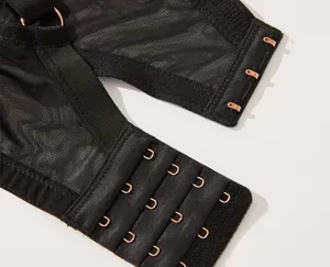 Close-up of the back closure and mesh details of a black plus-size supportive bra with hooks.