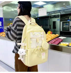 Cute yellow canvas school backpack detail view with cloud pendant and mini coin purse.