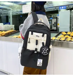 Detail view of a black and white school backpack with star patterns and a mini purse.