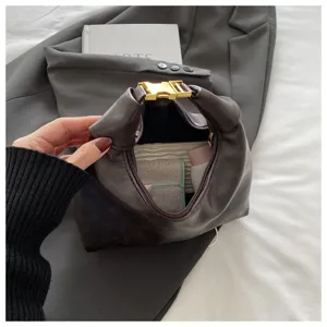 Detail shot of stylish vintage brown leather hobo dumpling shoulder bag with gold buckle.