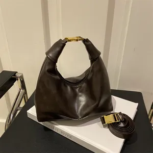 Brown leather hobo dumpling shoulder bag with stylish gold buckle closure and knot handle design.