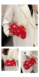 Detail view of Chinese style embroidered red handbag with gold chain and clasp closure.