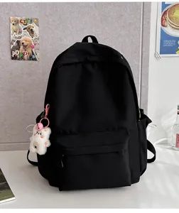 Detail shot of black casual school backpack with cute bear keychain and spacious design.
