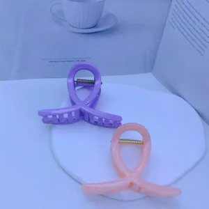 Detailed view of medium colorful geometric hair claws, sweet pink and purple design for styling.