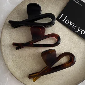 Matte black and tortoise shell hair claw clips set, large acrylic shark clips for women's styling.
