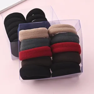 Gros plan d'élastiques à cheveux épais et élastiques en boîtes transparentes, couleurs variées.