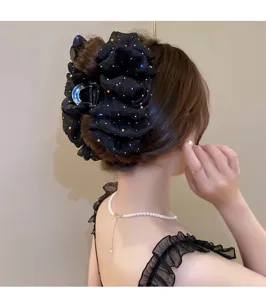 Vue de détail de la grande pince à cheveux en résille noire nœud papillon strass brillants.